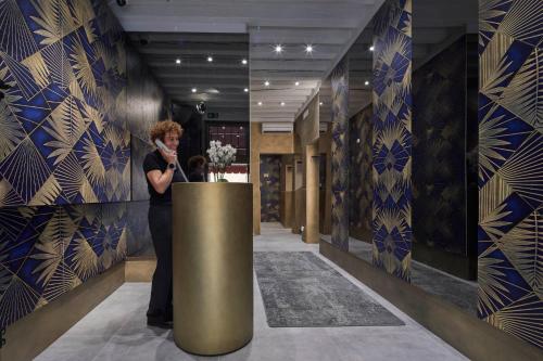 una mujer hablando en un celular en el vestíbulo en Hotel Orsaria, en Venecia