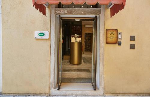a doorway to a building with a large gold barrel at Hotel Orsaria in Venice