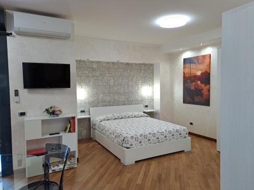 a bedroom with a bed and a flat screen tv at La casa sul molo - Acquario in Genoa