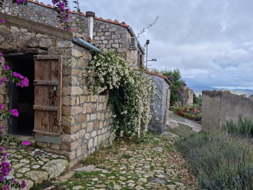 uma casa de pedra com flores ao lado dela em Casa Cipampini em Petralia Soprana