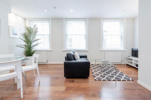 Sala de estar con silla negra y mesa en Roomspace Serviced Apartments - Sterling House, en Londres