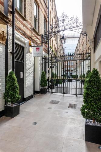 un patio vacío con una puerta de hierro negro en Roomspace Serviced Apartments - Sterling House, en Londres
