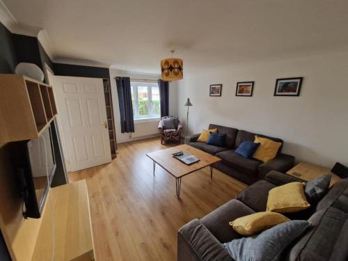 a living room with a couch and a table at Riverside home. 3 bedroom. Free parking. 10 mins to Newcastle City Centre in Dunston