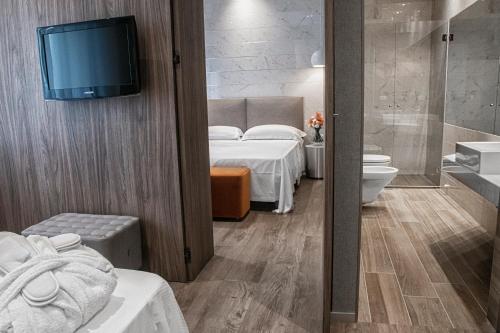 a room with two beds and a tv on a wall at AmbientHotels Panoramic in Rimini