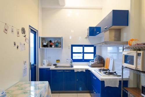 a kitchen with blue cabinets and a white stove top oven at 太平山愛琴海 in Gongzhao