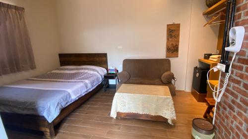 - une chambre avec un lit et une chaise dans l'établissement Inn-itiate Tainan, à Tainan