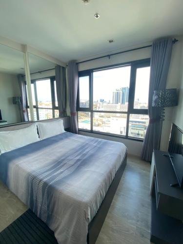 a bedroom with a large bed and large windows at The Base in pattaya in Pattaya Central