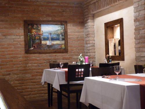 a restaurant with two tables and a painting on the wall at Pensione Ristorante Moretti in Nitra