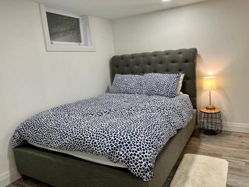 um quarto com uma cama com um edredão preto e branco em Adorable 1 Bedroom Suite With Kitchen Fireplace em Cambridge
