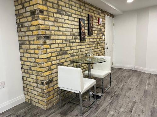 uma parede de tijolos num quarto com uma mesa e cadeiras em Adorable 1 Bedroom Suite With Kitchen Fireplace em Cambridge
