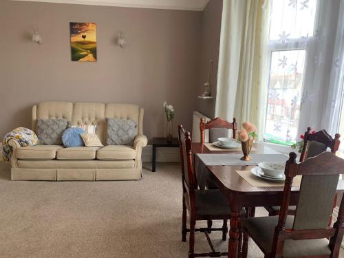 ein Wohnzimmer mit einem Tisch und einem Sofa in der Unterkunft Cosy 2 bed flat in Baffins in Portsmouth
