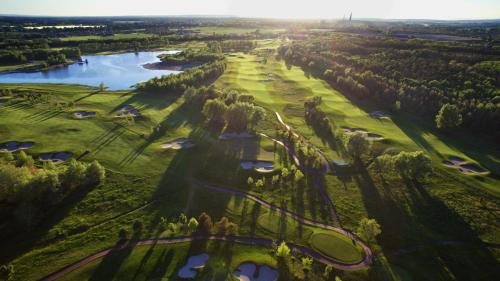 an aerial view of a golf course with a river and trees at Golf & Spa Kunětická Hora in Dritec