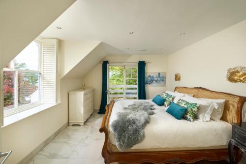 a bedroom with a large bed with blue pillows at Hazelbank, sleeps 10, on the shores of Loch Fyne in Cairndow