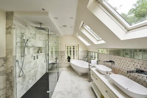 a bathroom with two sinks and a glass shower at Hazelbank, sleeps 10, on the shores of Loch Fyne in Cairndow