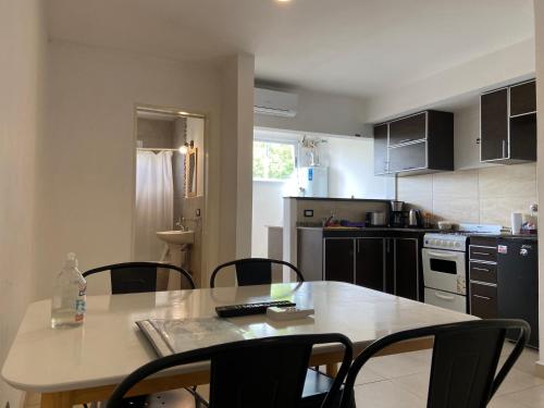 a kitchen with a table and some chairs and a table and a kitchen with at Mendoza Apartments Ezeiza Airport in Luis Guillón