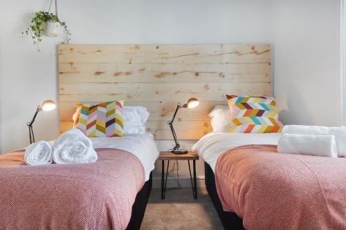 two beds sitting next to each other in a room at Stylish Eco-Friendly Apartments in Folkestone in Folkestone