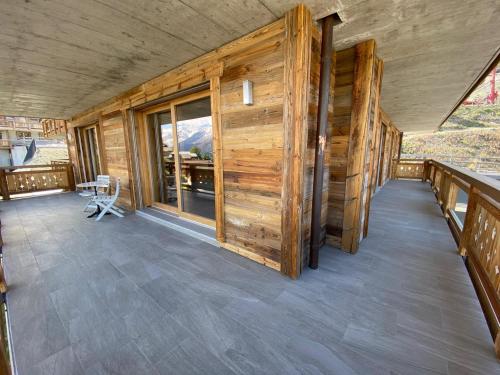 an empty porch of a cabin with wooden walls at Aiguilles Rouges - Tête Blanche - Thermes de la Dixence in Hérémence