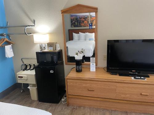 a hotel room with a bed and a television at Days Inn by Wyndham Lexington in Lexington