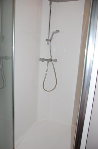 un baño con ducha junto a una puerta de cristal en Iconique bv Appartement in hartje Ieper, en Ypres