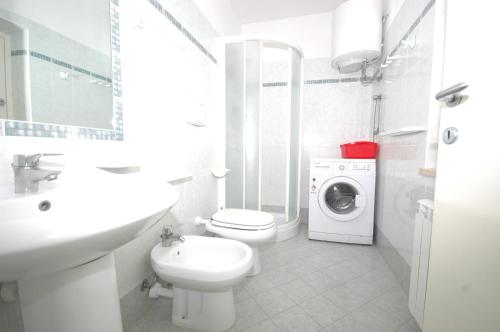 a bathroom with a toilet sink and a washing machine at Pozzo al Moro in Marina di Campo