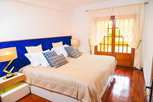a bedroom with a large bed with a blue headboard at Charming Home in Sintra Village in Sintra