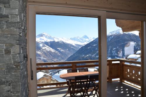 a balcony with a table and a view of mountains at Aiguilles Rouges - Tête Blanche - Thermes de la Dixence in Hérémence