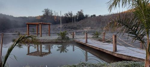 a wooden bridge over a body of water at Casarão Biazolli in Farroupilha
