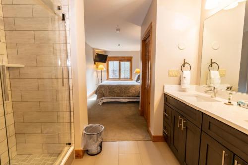a bathroom with a sink and a shower and a bed at Expedition Station by Summit County Mountain Retreats in Keystone