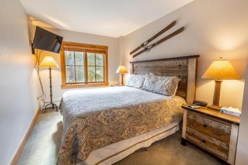 a bedroom with a large bed and a dresser with a lamp at Expedition Station by Summit County Mountain Retreats in Keystone
