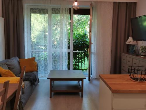 een woonkamer met een bank en een tafel bij Apartament w parku in Oświęcim