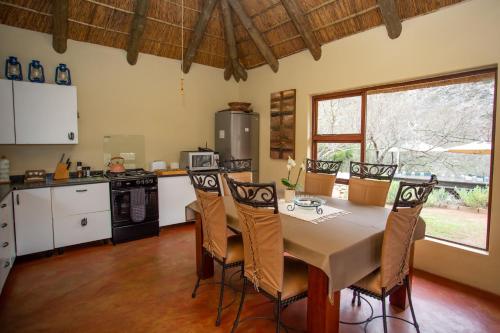 eine Küche mit einem Tisch und Stühlen im Zimmer in der Unterkunft Indalu Game Reserve in Boggomsbaai