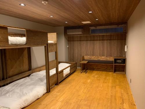 広島市にあるHotel San Hiroshimaの二段ベッド2組が備わるウッドフロアの客室です。