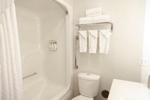 a bathroom with a shower and a toilet and towels at Holiday Inn Express Marshfield - Springfield Area, an IHG Hotel in Marshfield