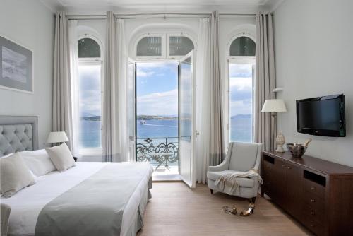 a bedroom with a large bed and a television at Poseidonion Grand Hotel in Spetses