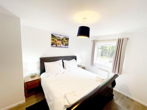 a bedroom with a bed and a window at Matara House Holiday Home in Inverness