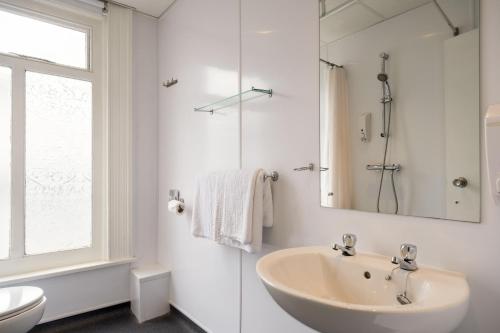 uma casa de banho branca com um lavatório e um chuveiro em Comfort Inn Birmingham em Birmingham