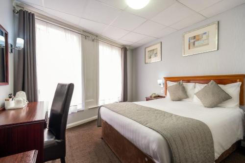 a hotel room with a bed and a desk and window at Comfort Inn Birmingham in Birmingham