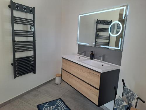 ein Bad mit einem Waschbecken und einem Spiegel in der Unterkunft chambre d'hôtes chez Jessica et Pascal in Barjols