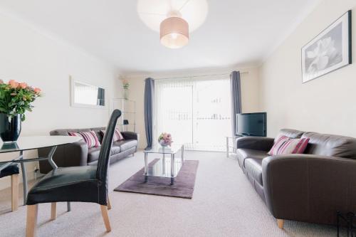 uma sala de estar com um sofá e uma mesa em Roomspace Serviced Apartments - Cascades Court em Londres