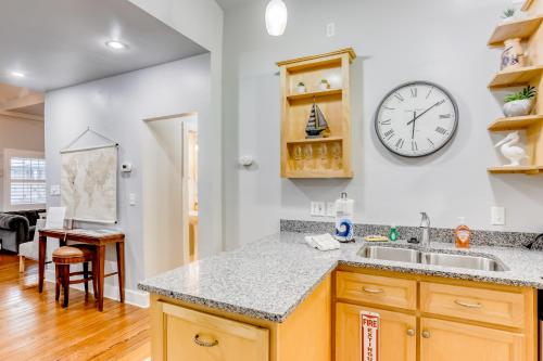 a kitchen with a sink and a clock on the wall at Quaint Modern Downtown Cottage in Saint Augustine