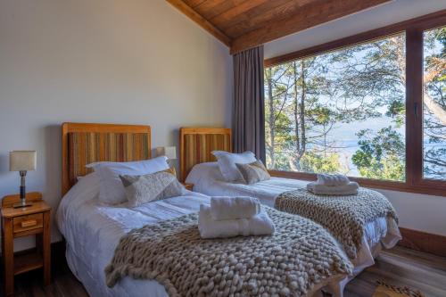 Кровать или кровати в номере Peñon de Arelauquen Suites del Lago Bariloche 2D