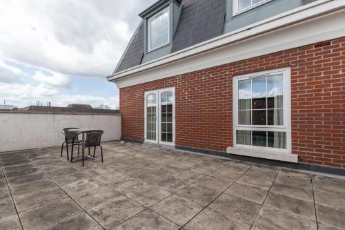 a patio with a table and chairs next to a brick building at Roomspace Serviced Apartments - Central Walk in Epsom