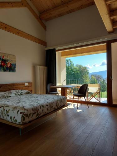a bedroom with a bed and a table and chairs at La casa di Maia - Alloggio Agrituristico in Pedavena