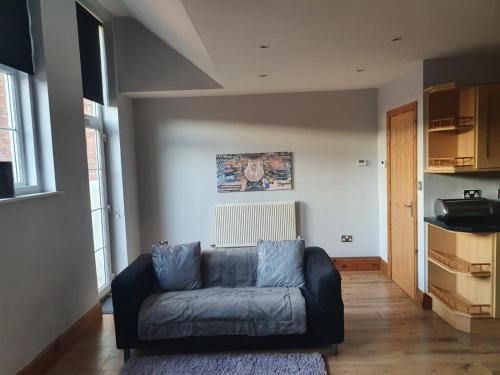 a living room with a blue couch in a room at Spacious fully furnished 2 bed appartment next to BAE, in Barrow in Furness