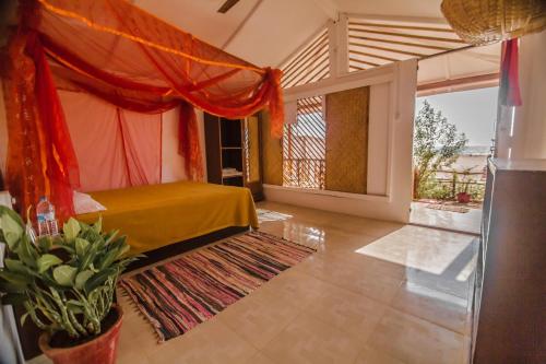 ein Schlafzimmer mit einem Bett und einem großen Fenster in der Unterkunft Sonho do Mar in Agonda
