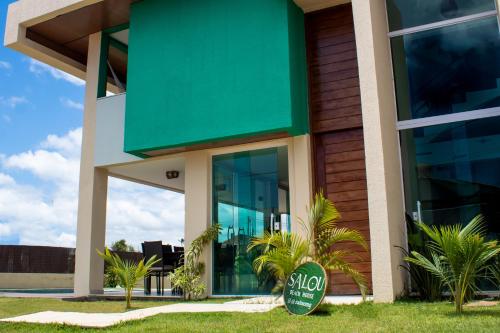 a building with a green sign in front of it at Espetacular Casa de Charme em São Miguel do Gostoso - Salou in São Miguel do Gostoso