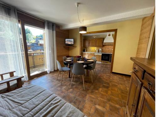 une cuisine et une salle à manger avec une table et des chaises dans l'établissement Neige et Roc 2 - Appartement 2 chambres centre, à La Clusaz