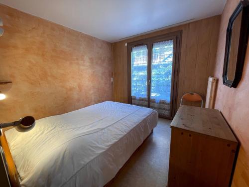 une chambre avec un lit, un bureau et une fenêtre dans l'établissement Neige et Roc 2 - Appartement 2 chambres centre, à La Clusaz