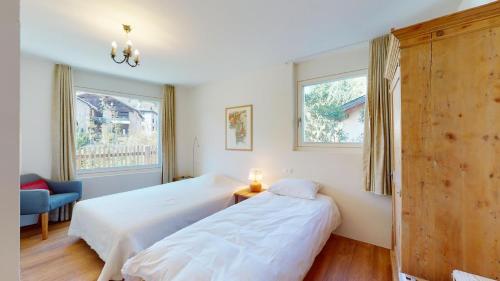 a bedroom with two beds and a window at Abitaziun Bellaval 1A - Celerina in Celerina