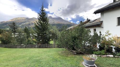 a yard with a house and a fence with mountains at Abitaziun Cuntainta 1 - Champfèr in Champfer